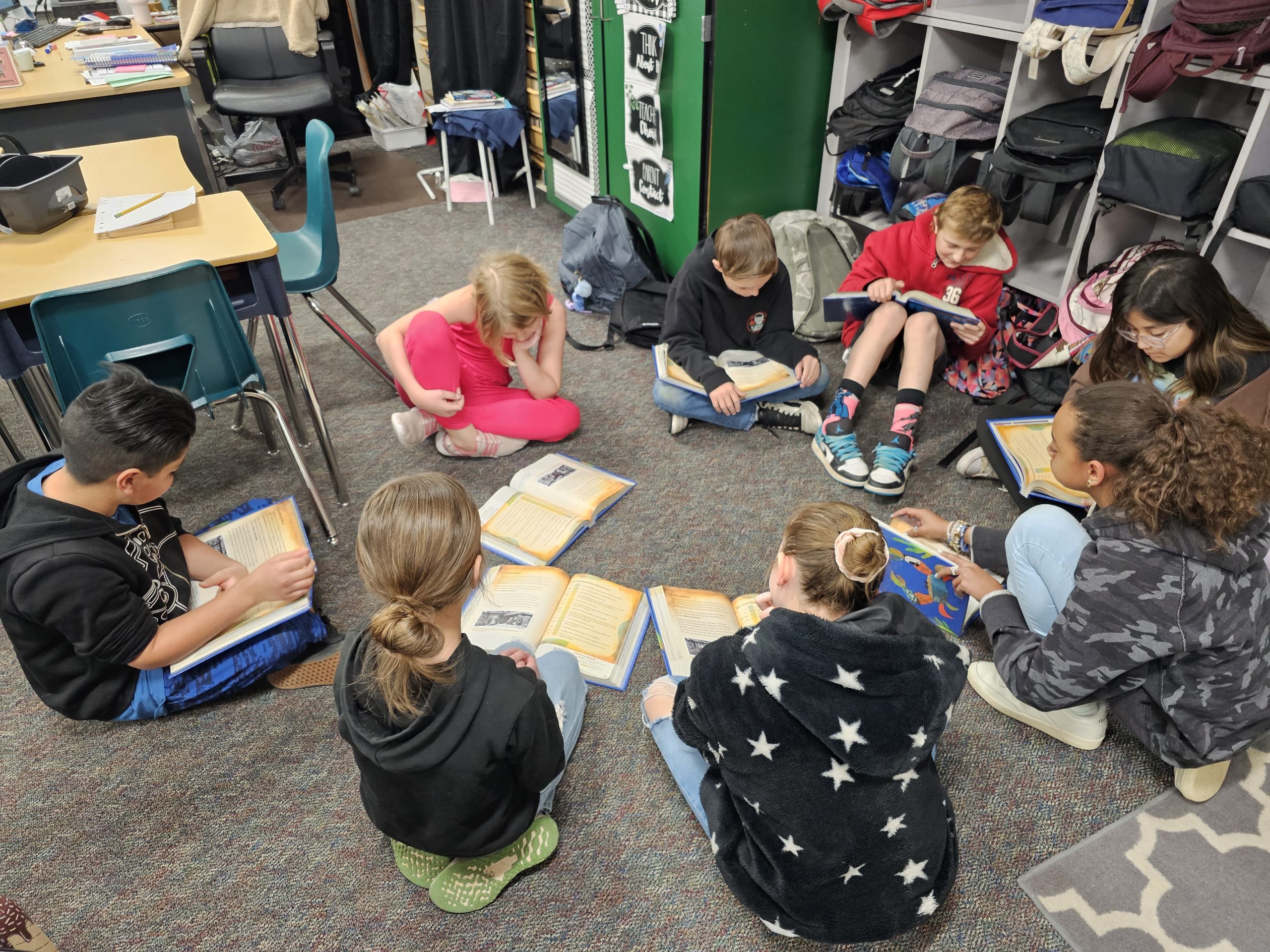Students sitting in a circle reading books. 